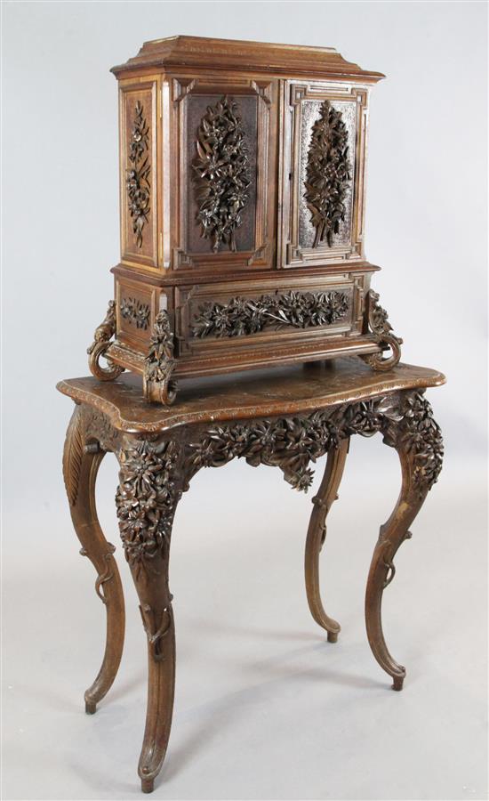 A late 19th century Black Forest relief carved wood cabinet on stand, W.2ft 5in. D.1ft 2in. H.4ft 6in.
